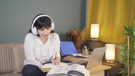 estudiante masculino escuchando música y estudiando por la noche.