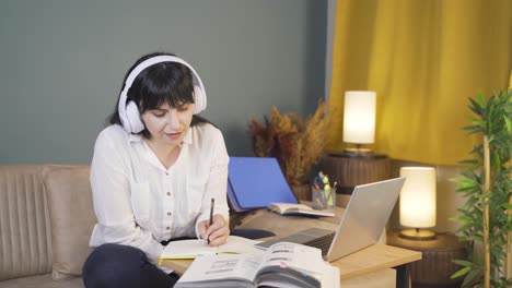 male student listening to music and studying at night.