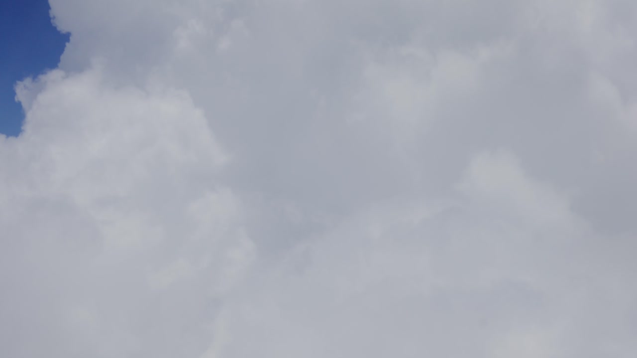 View of large clouds covering screen outside of chromatic airplane window, Santorini, Greece, Europe