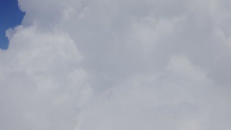 view of large clouds covering screen outside of chromatic airplane window, santorini, greece, europe