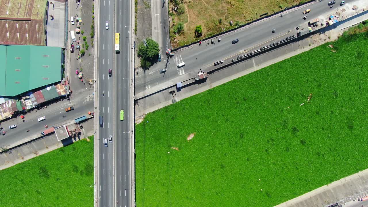 하향식 보기는 백합으로 뒤덮인 수로와 교량, 도로, 쇼핑몰 및 아파트 단지가 교차하는 모습을 보여줍니다.