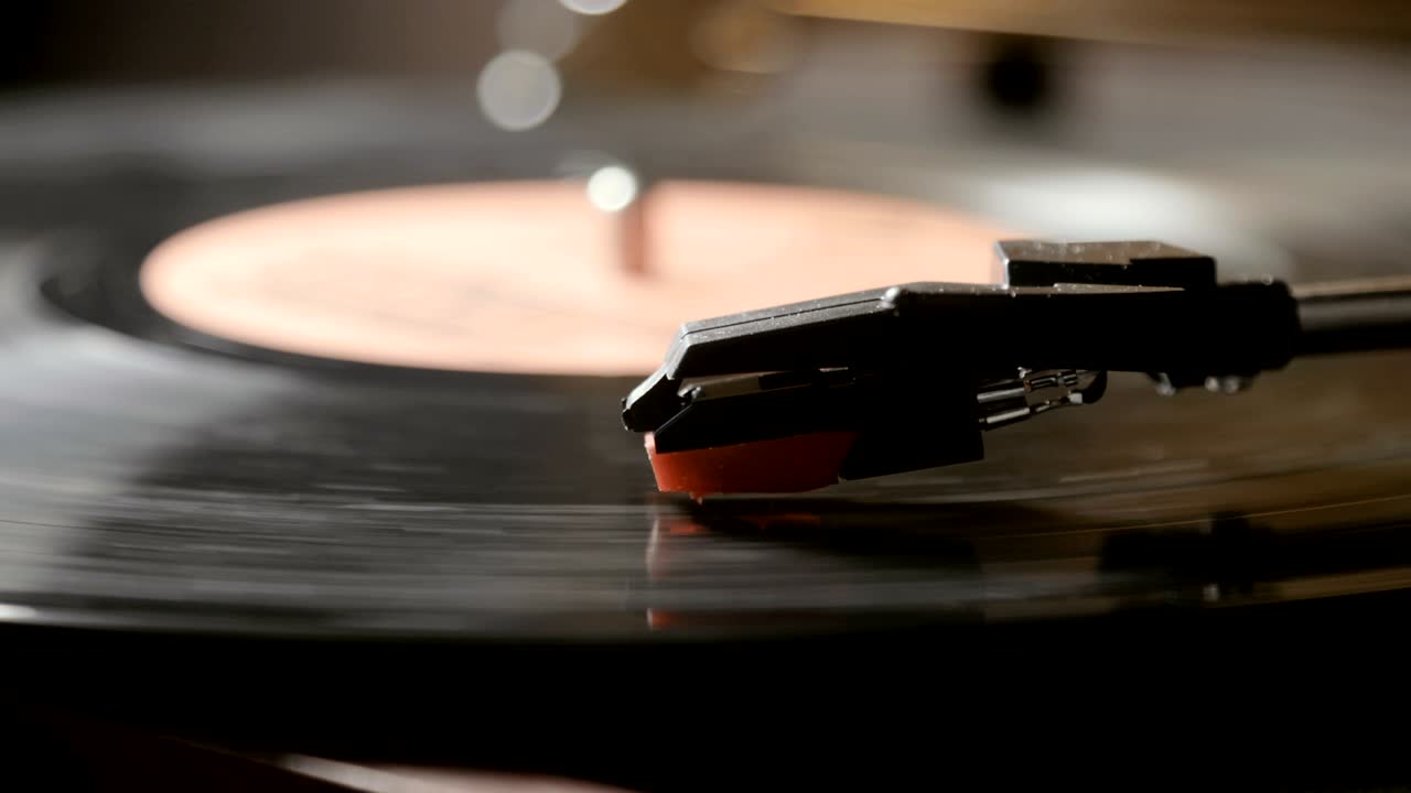 고대 비닐 레코드 플레이어를 사용하는 클로즈업. 턴테이블 플레이어, 비닐 레코드를 재생하는 스타일러스 바늘을 떨어뜨리는
