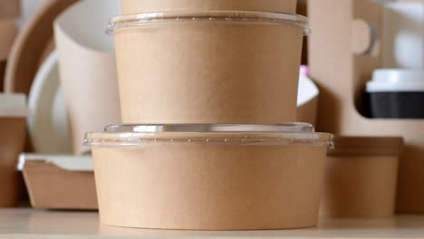envases redondos biodegradables de papel para alimentos sobre el fondo de utensilios de mesa desechables de papel.