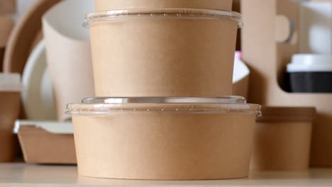 paper biodegradable round containers for food on the background of paper disposable tableware.