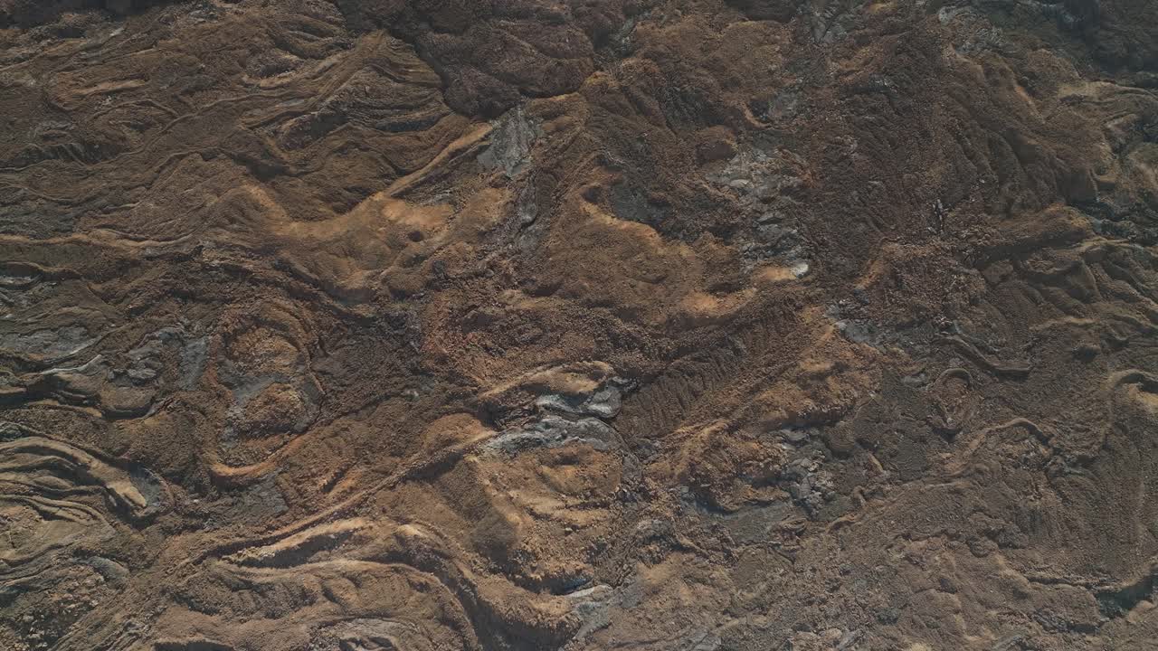 Textured solid rock terrain formed after intense lava flow from volcanic eruption