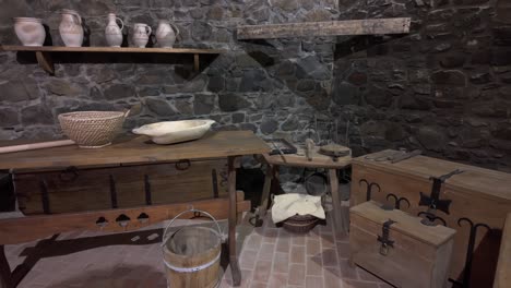 a medieval storage room inside hollókő castle with wooden chests, pottery, and stone walls, reflecting historical craftsmanship and daily life in a medieval castle.