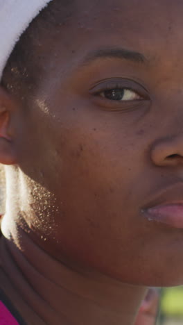 video of african american female tennis player holding racket and looking at camera