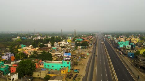 aerial drone shot of factories in india, showing pollution from chimneys against an industrial landscape.