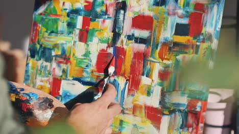 The-Hands-Of-An-Unrecognizable-Man-Painting-With-A-Spatula-On-An-Impressionist-Canvas-1