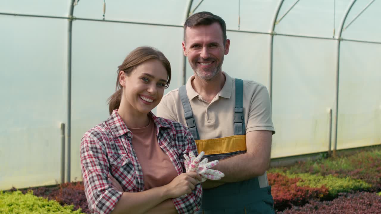 retrato de dos botánicos caucásicos de pie en el invernadero