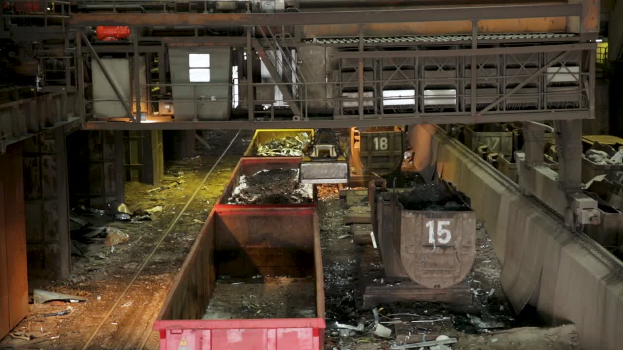 interior de la fábrica de acero industrial con cucharas que llevan metal fundido, filmado con poca luz, que transmite la atmósfera de la industria pesada