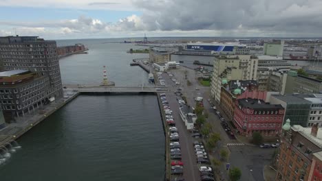 aerial flight over canal in malmö city, sweden. harbor and ship in the background