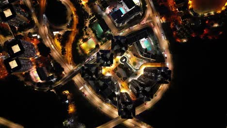 A breathtaking drone view of Hong Kong at night, showcasing the glowing skyline, busy harbor, and vibrant city lights from above.