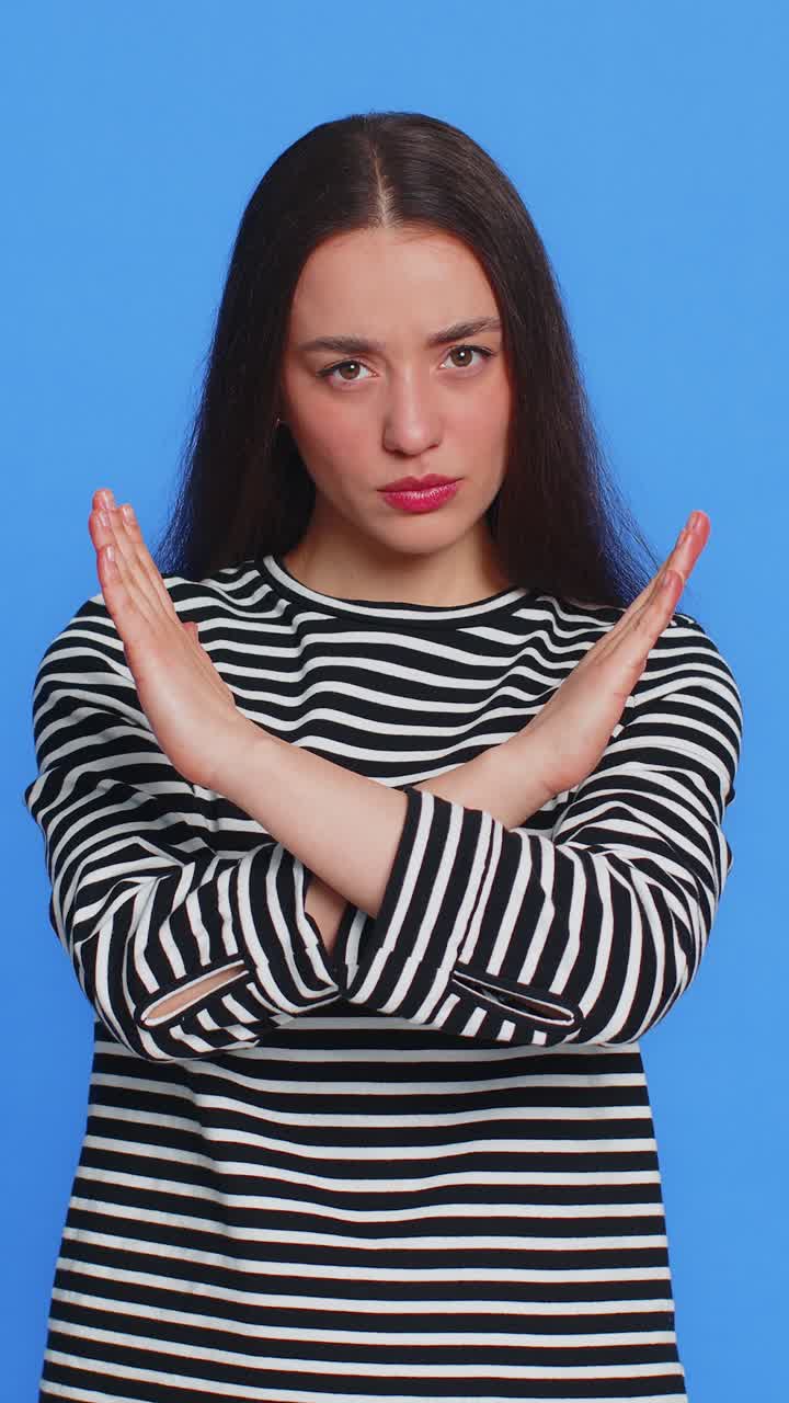 la mujer dice que no. la palma de la mano doblada, las manos cruzadas en el gesto de parada, advertencia de final, acceso prohibido.