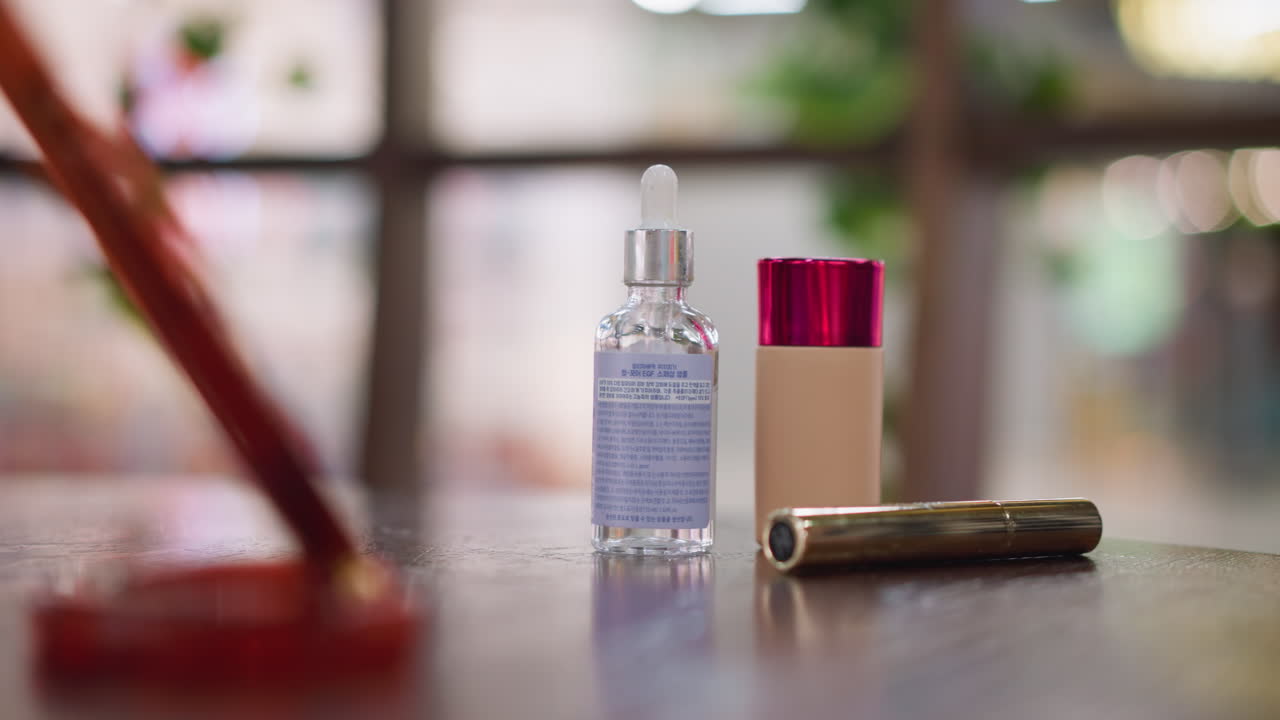 나무 테이블에 미용 제품을 배열하는 사람의 가까운 손 시각, 유리 세럼 병과 화장품 용기 초점, 하나의 롤링, 부드러운 조명 및 흐릿한 배경