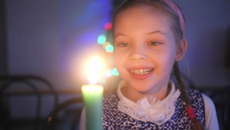 a smiling girl holding a candle