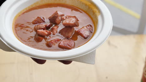 traditional goulash soup from slovenia with meat in a paper plate with a handkerchief under it