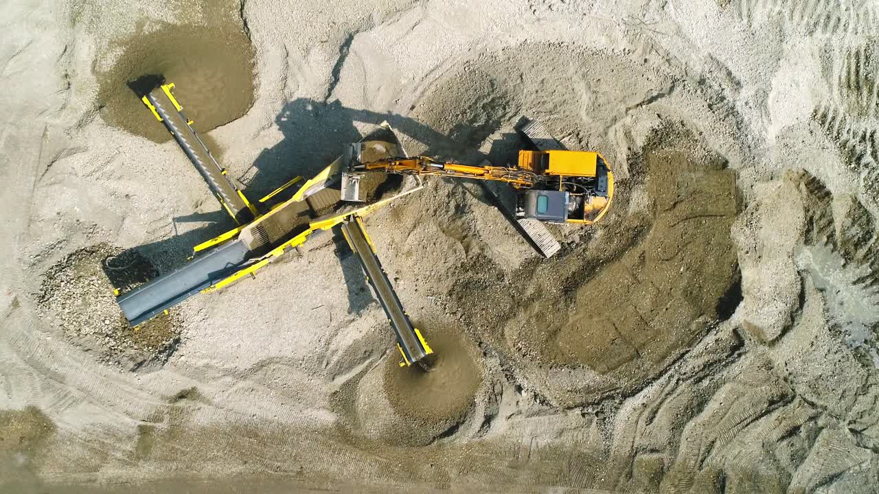 la excavadora carga la máquina de cribado en el sitio de construcción