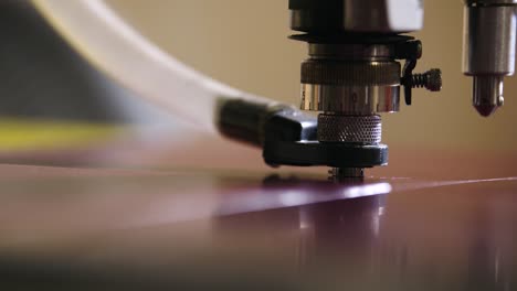 a braille engraver bores holes to be filled with braille dots in slow motion