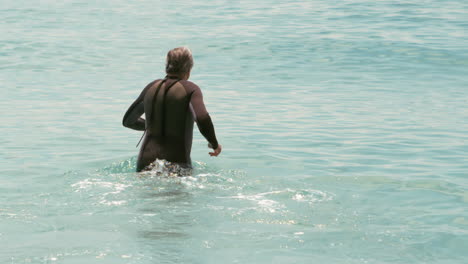 senior man in wet suit in the water