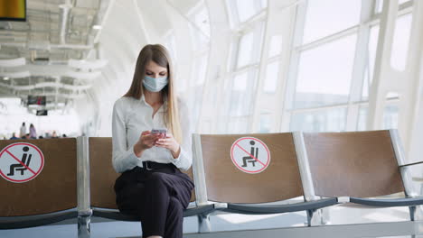 woman wearing a mask waiting at the airport