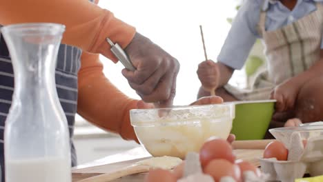 Feliz-Abuelo-Y-Nieto-Afroamericano-Horneando-En-La-Cocina,-Cámara-Lenta