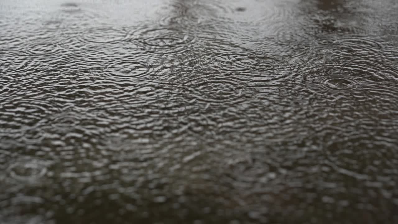 Rain droplets falling on ground on blurred background, beautiful nature rain season, splash of water fall motion on ground, light of sunny pass water is beauty, close up view raindrop on heavy weather