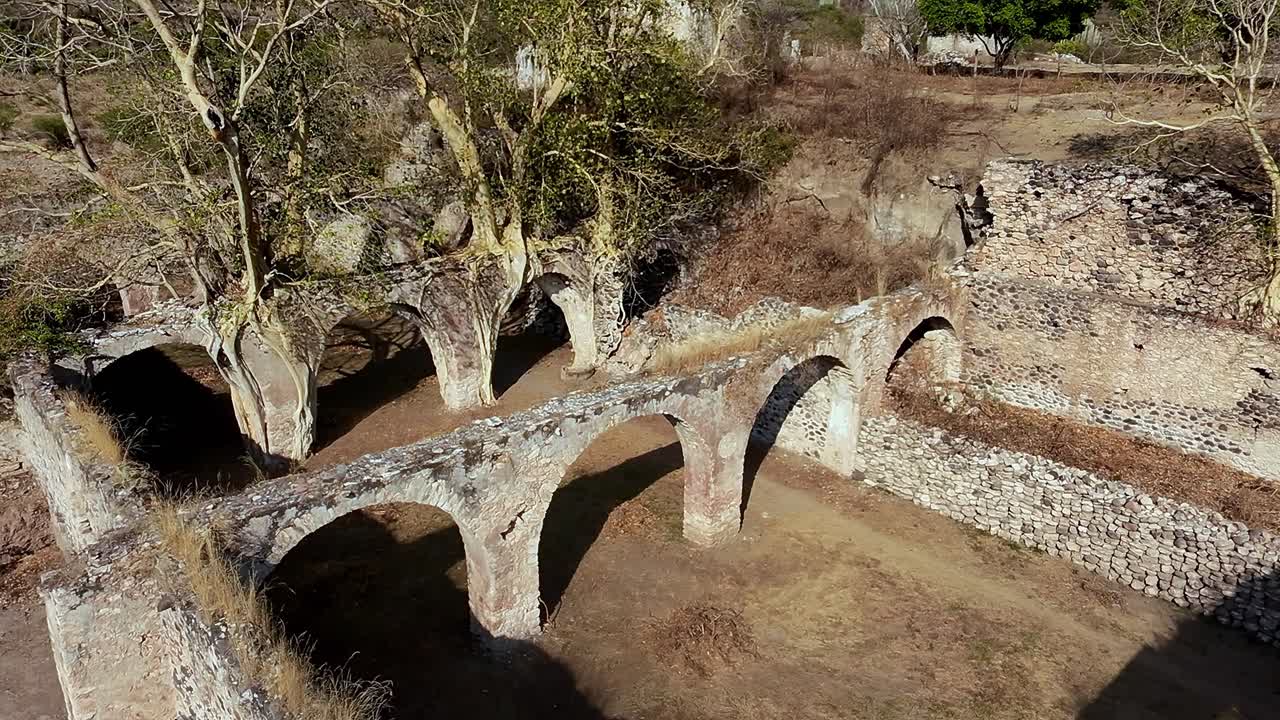 Crumbling arches and weathered stone walls of the historic Hacienda de San Jacinto Ixtoluca in Morelos, Mexico, stand as a testament to time, with nature slowly reclaiming the once grand estate