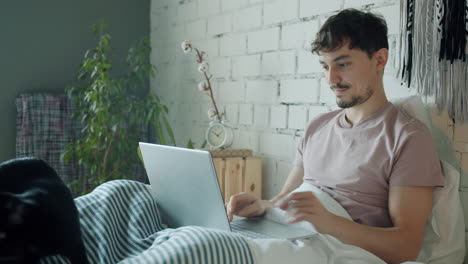 man working from bed