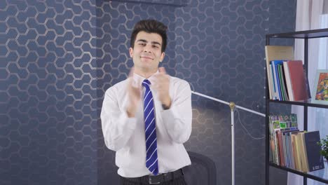 un hombre de negocios exitoso aplaudiendo en la oficina.