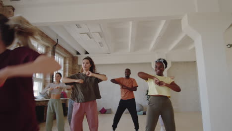 cheerful people dancing with female coach and taking break