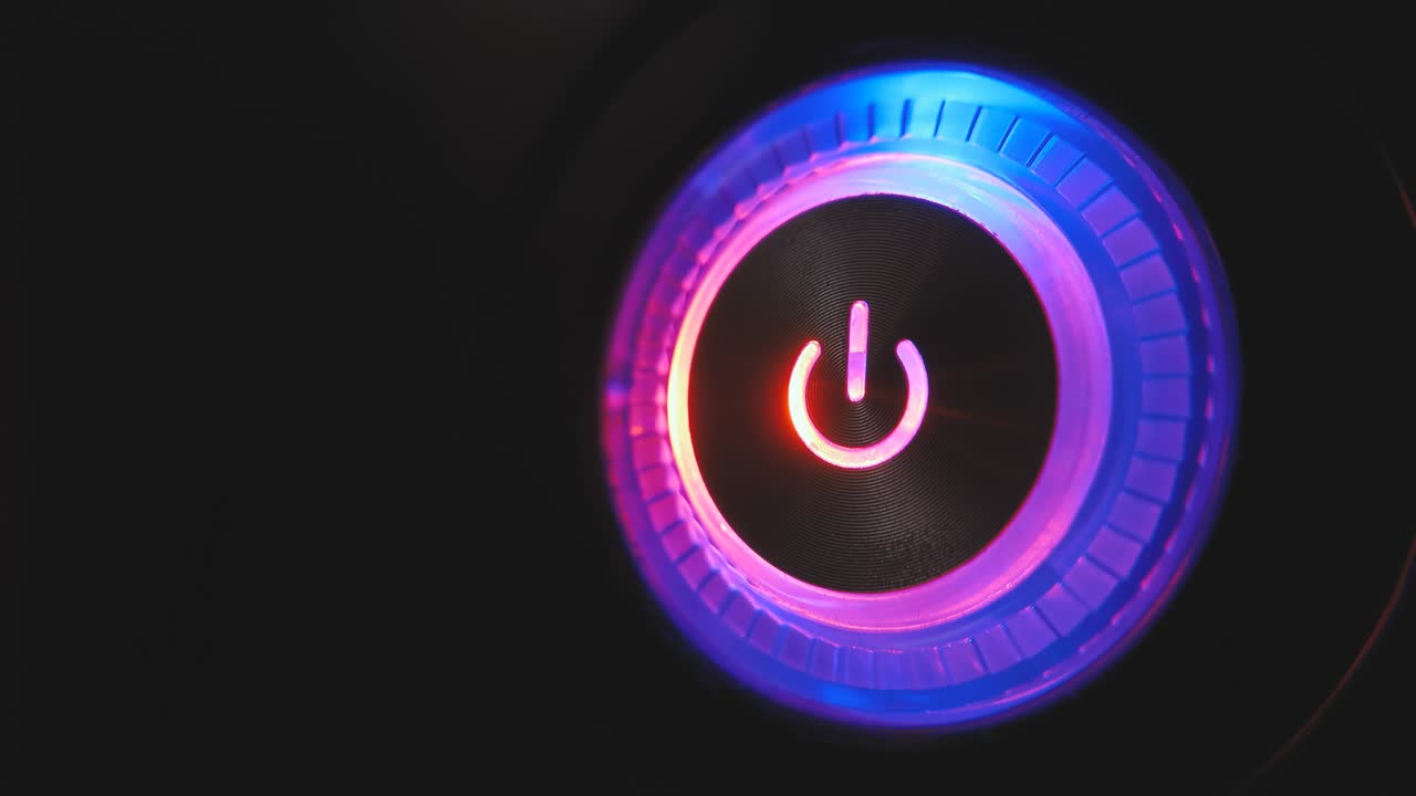 un bucle de video macro de 4k de un botón de encendido de la computadora en la unidad del sistema sobre un fondo negro.