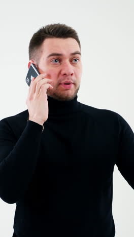 Portrait of handsome man talking the phone indoors. Young businessman having a conversation through the telephone. E business concept. Vertical video