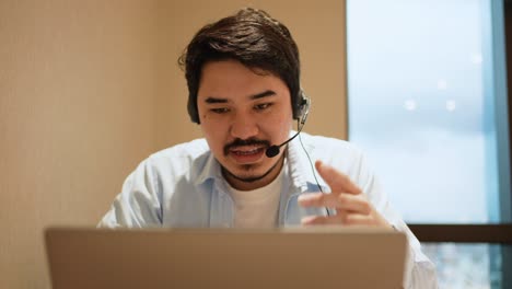 slow motion scene middle eastern adult call center employee man smiling with wear headset while talking with customer in operation office for contact us and telemarketing job concept