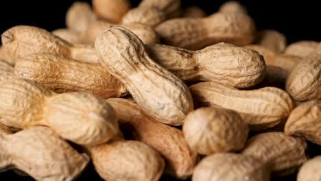 Peanuts-in-shell-fall-on-table-from-above