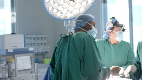 diversas mujeres y hombres cirujanos con máscaras comprobando el equipo durante la operación, cámara lenta