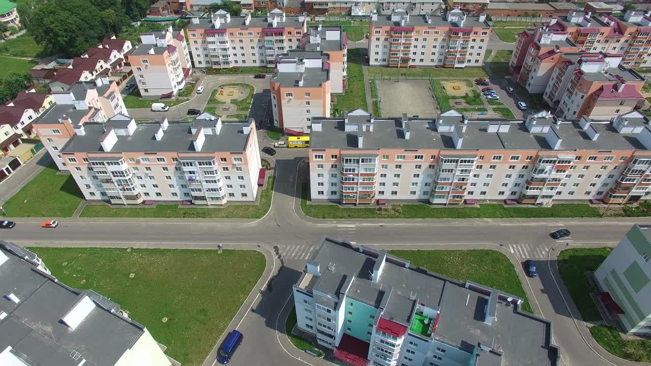 New residental building appartments in modern complex near the green fields in summer. Beautiful flying over the city in a new district. Aerial view