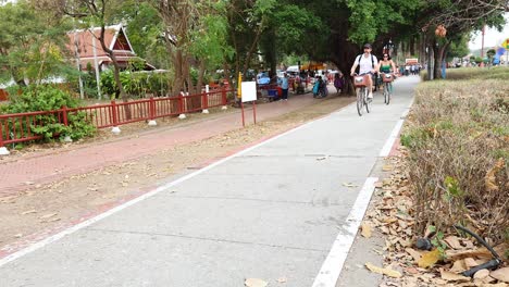 people cycling down a scenic park path