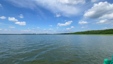 a boat sails across a lake in beautiful weather