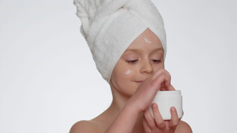 encantadora niña joven aplicando limpieza hidratante crema facial cuidado de la piel crema natural cosméticos