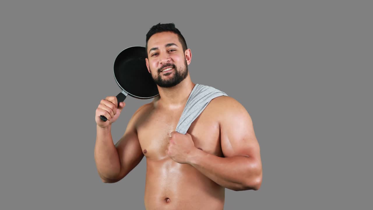 hombre musculoso sonriente sosteniendo una sartén