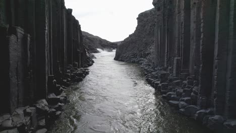aerial fly-through shot of the studlagil canyon basalt columns in east iceland