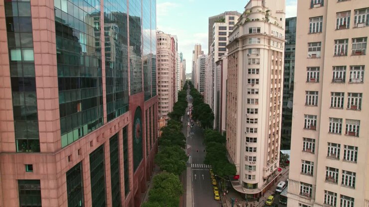 Câmera em aproximação no centro histórico do Rio de Janeiro, Avenida Rio Branco, mostrando o contraste arquitetônico com o Metrô na superfície.