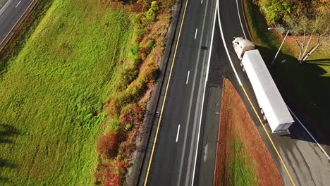 aerial of a semi truck traveling on a highway road through the fog in fall 1