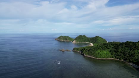 aerial view of vast ocean bay with waves crashing against coastline of catanduanes, full of lush jungles and beautiful white sand beaches