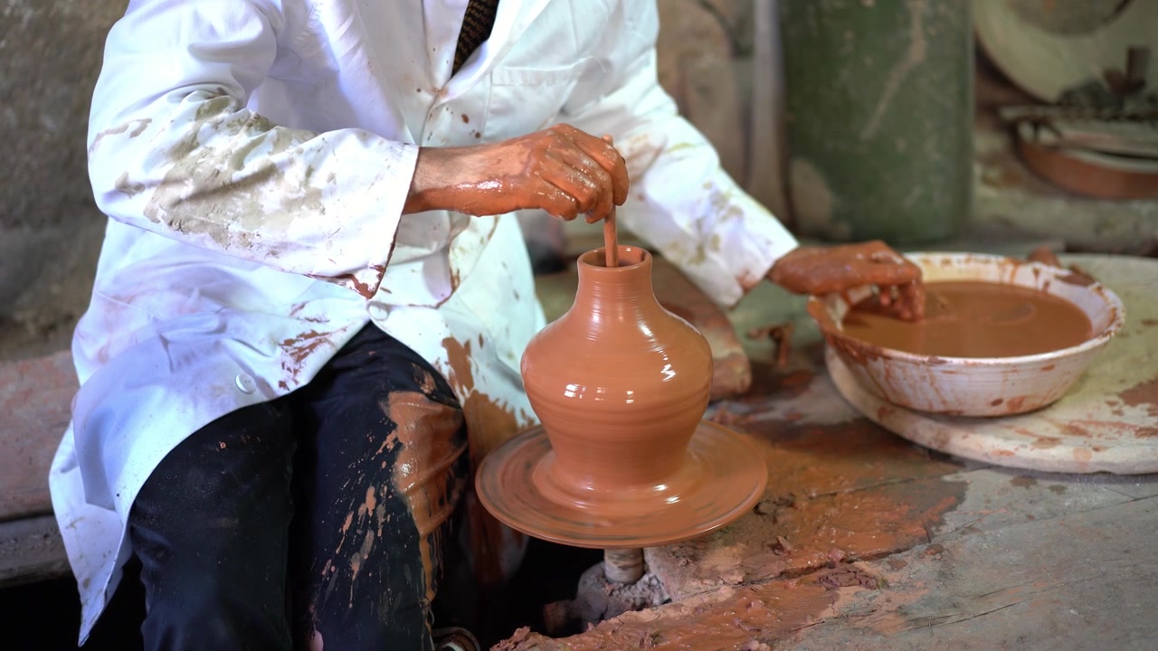Artigiano che modella un pezzo di ceramica su un tornio da vasaio arabo.