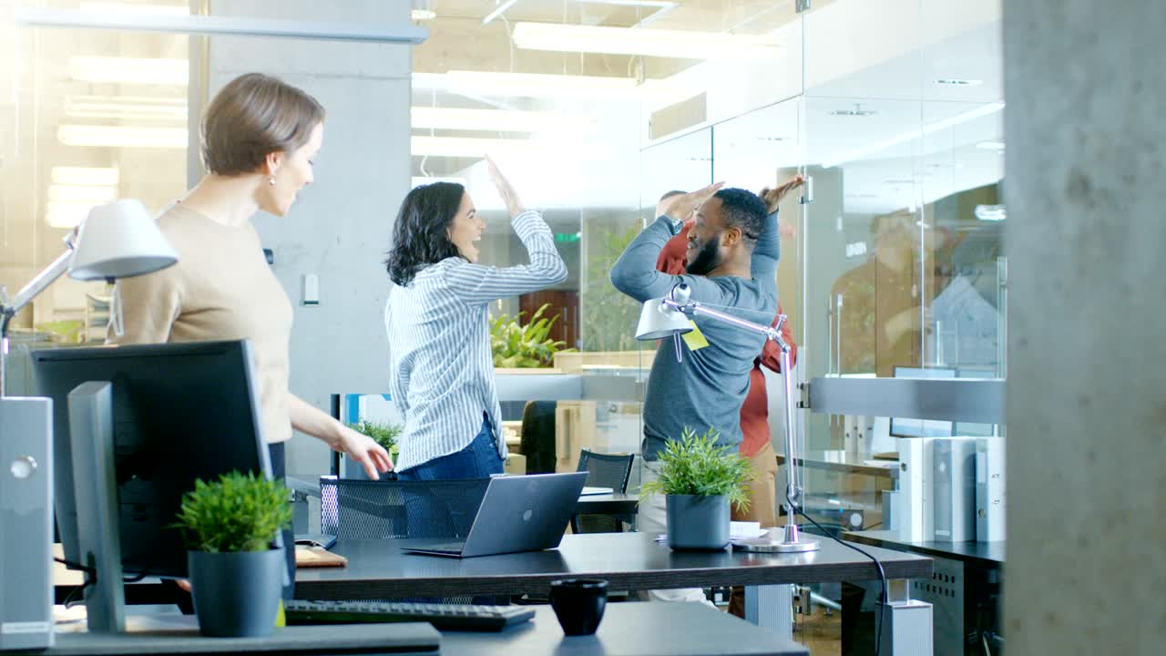 젊은 여성과 남성의 다양한 그룹이 현대적인 사무실에서 춤을 추고 재미있게합니다.