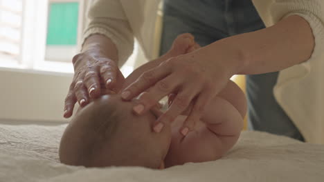 mother plays with baby boys arms, hands, caresses newborn child