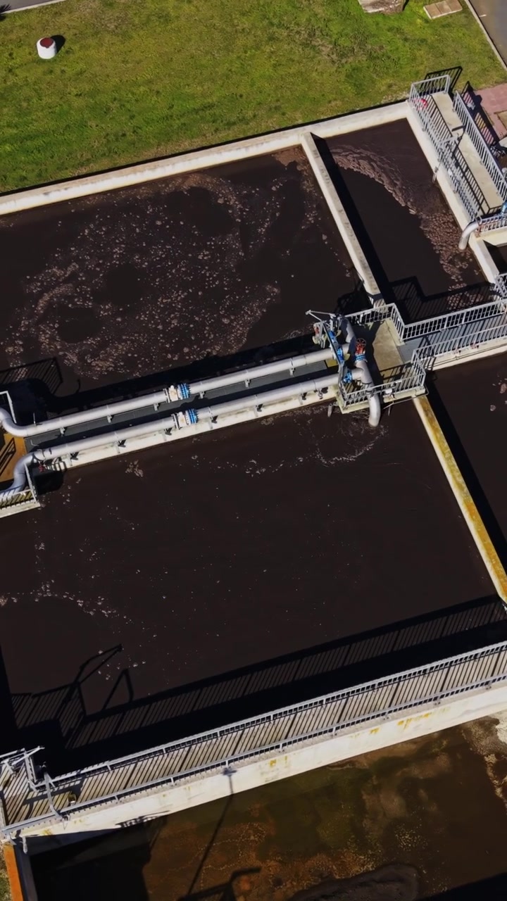 Water treatment plant uses large tanks and pipes in bright light