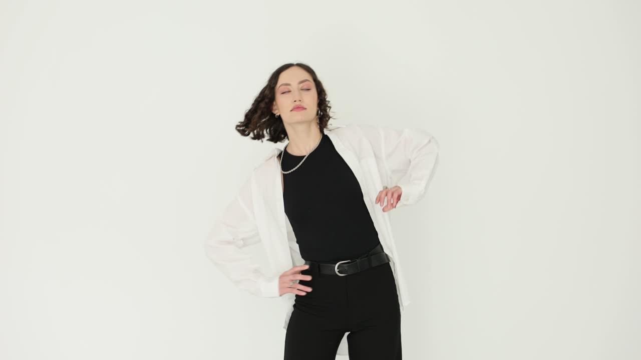 Young Woman Posing Gracefully in Black and White Outfit in Studio